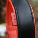 Zoom sur étiquette prénom en cuir orange sur collier de chien en cuir noir